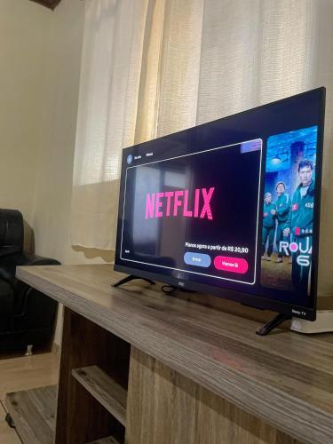 a tv on a table with a netflix sign on it at Conforto no Centro da Cidade in Alta Floresta