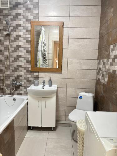 a bathroom with a sink and a toilet and a mirror at Однокімнатна квартира в центрі, на вулиці Набережна,10 з парковкою in Luts'k