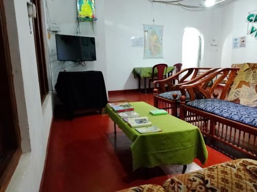 a living room with a green table and chairs at Green Villa in Nuwara Eliya