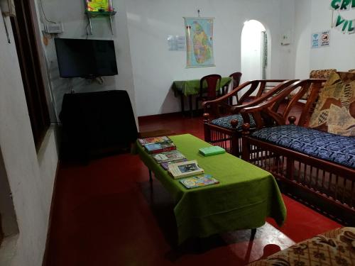a living room with a green table and chairs at Green Villa in Nuwara Eliya