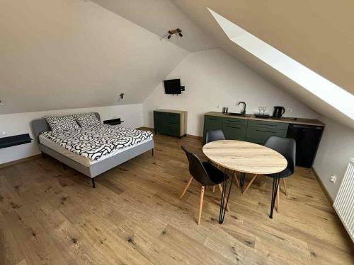 a bedroom with a bed and a table and chairs at Pokoje Gościnne Nad Jeziorem in Rajgród