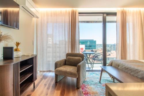 a living room with a chair and a room with a view at HILCROWN 39 Studios by LovelyStay in Vila Nova de Gaia