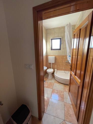 a bathroom with a toilet and a bath tub at Rooms Ibrocevic in Ulcinj