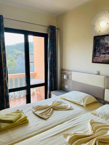 a bedroom with a bed with a view of a balcony at Rooms Ibrocevic in Ulcinj
