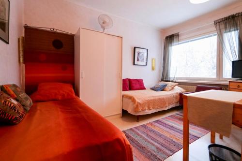 a bedroom with two beds and a table and a window at Majoitus Puistotie in Mänttä