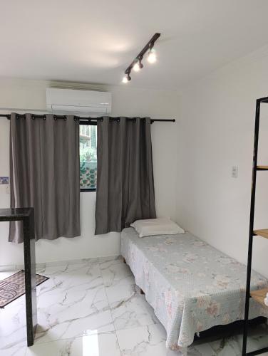 a bedroom with a bed and a window at Casa Nova Centro de Penedo-Quitinete in Penedo
