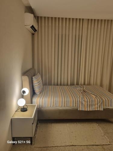 a bedroom with a bed and a side table with a lamp at Chez-moi in Sfax