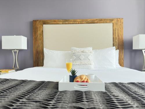 a white bed with a tray of food on it at Private Oasis at Arya in Miami