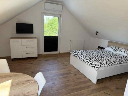 a bedroom with a bed and a television and a table at Pokoje Gościnne Nad Jeziorem in Rajgród