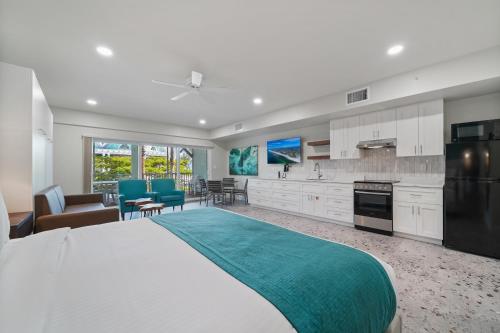 a large bedroom with a large bed and a kitchen at Bridgewalk, a Landmark Resort in Bradenton Beach