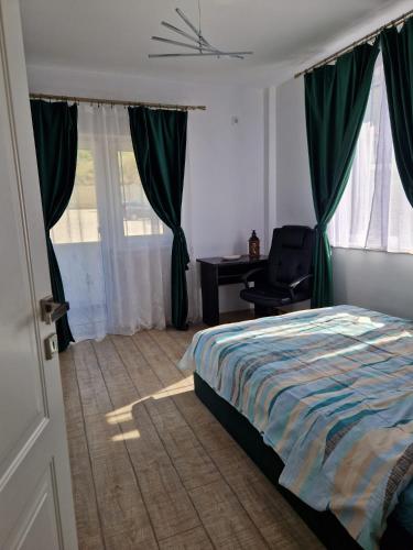 a bedroom with a bed with green curtains and a desk at Bucium Hills Retreat in Iaşi