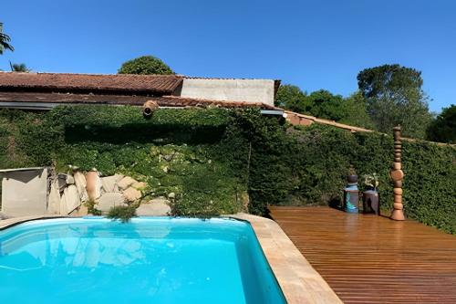 a backyard with a swimming pool and a wooden deck at Casa LARVC no coração de Pirenópolis! in Pirenópolis