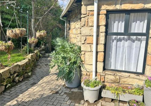 a brick house with a window and some plants at The Victoria House in Ficksburg