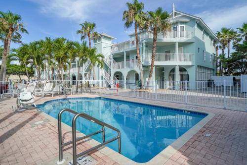 a swimming pool in front of a house with palm trees at Bridgewalk, a Landmark Resort in Bradenton Beach