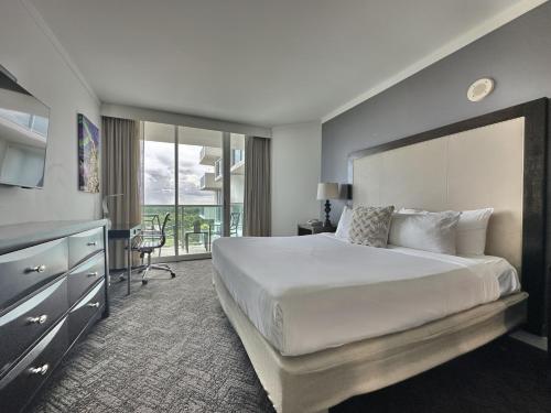 a bedroom with a large white bed and a desk at Private Oasis at Arya in Miami