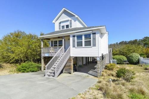 a large white house with a porch and stairs at 4040 - Paws at the Beach in Kitty Hawk Beach