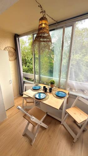une pièce avec une table et des chaises et une grande fenêtre dans l'établissement Studio cosy à 200m de la mer!, à Saint-Raphaël
