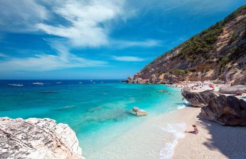 カーラゴノネにあるCasa Vacanze Gustuiの水中の人々と岩の浜