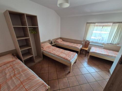 a room with three beds in a room at Zajazd PTTK Pod Roztoką in Rytro