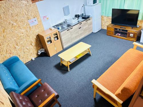 a living room with furniture and a sink and a tv at ゲストハウス宮町 Guest House Miyamachi in Ise