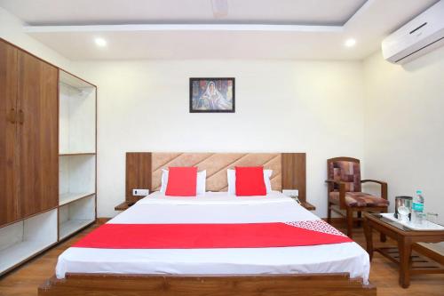 une chambre avec un grand lit blanc avec des oreillers rouges dans l'établissement Hotel O Amaze Inn Indo Pak Bus Stand, à Amritsar