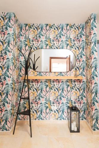 a mirror on a wall with a tropical wallpaper at Brisas de Güimar in Santa Cruz de Tenerife