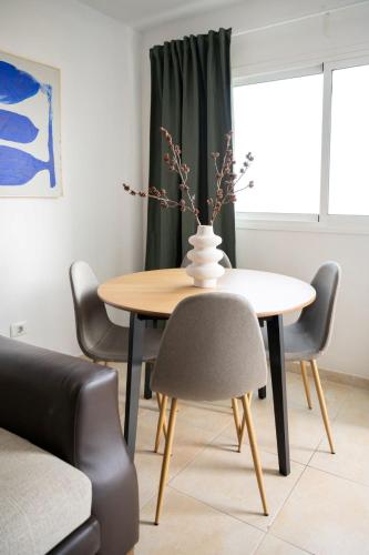 a dining room table and chairs with a vase on it at Brisas de Güimar in Santa Cruz de Tenerife