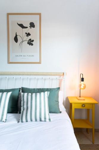 a bedroom with a white bed with striped pillows at Brisas de Güimar in Santa Cruz de Tenerife