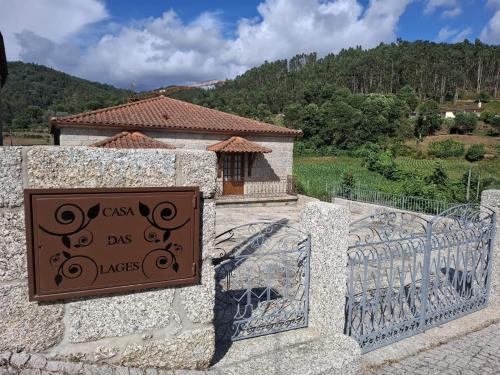 a sign on a stone wall with a gate at Casa das Lages in Vieira do Minho