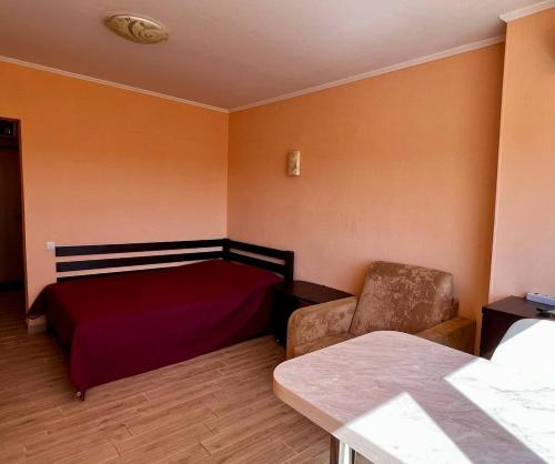 a bedroom with a bed and a chair in it at Променад Бугаз in Zatoka