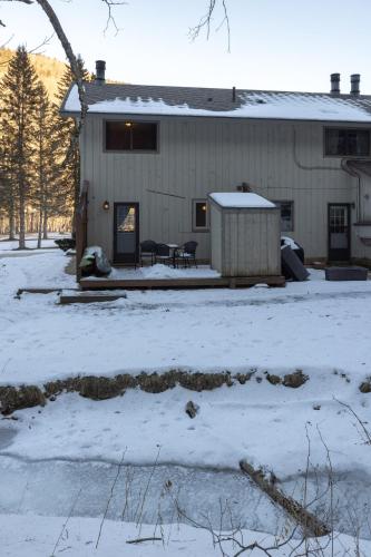 a house covered in snow in front of a building at Luxury Condo Tucked in the Heart of Killington in Killington