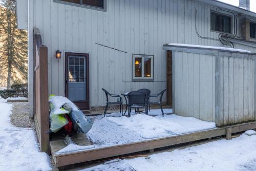 a porch with a table and chairs in the snow at Luxury Condo Tucked in the Heart of Killington in Killington