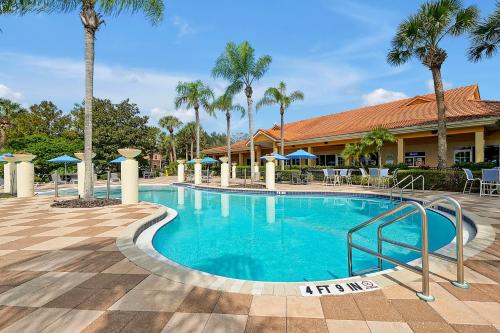 a swimming pool at a resort with palm trees at Encantada Resort Vacation Townhomes by IDILIQ in Kissimmee