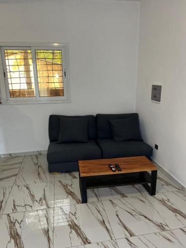 a living room with a blue couch and a coffee table at Chez Olympio in Cap Skirring