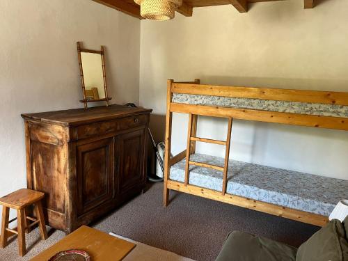 a room with a bunk bed and a dresser and a mirror at Les Soleils de la Meije in La Grave