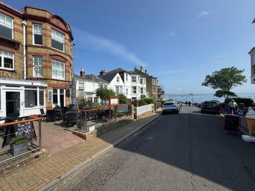 a street with houses and a car parked on the road at Suzetta Cottage in Seaview