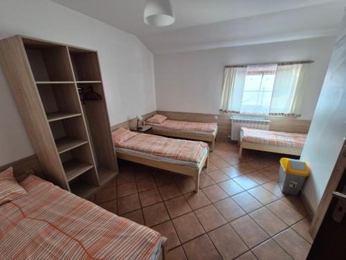 a room with three beds and a window at Zajazd PTTK Pod Roztoką in Rytro