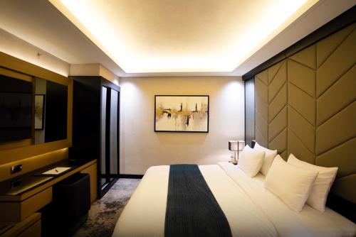 a hotel room with a bed and a television at The V Hotel in Baghdad