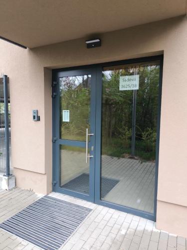 a glass door of a building with a sign on it at modern apartment in Senica