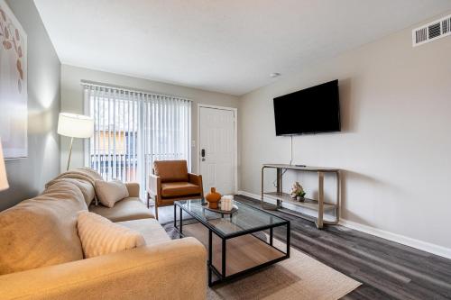 a living room with a couch and a flat screen tv at Landing Apartments - Castleton in Indianapolis