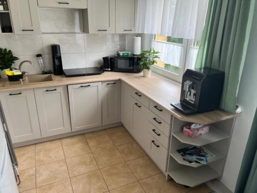 a kitchen with white cabinets and a counter with a microwave at Apartament Piaskowa Mountain & Coffee in Wałbrzych
