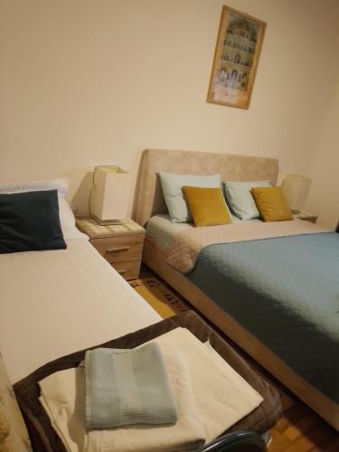 a room with two beds and a couch at Nada Apartman in Lastva
