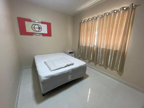 una piccola camera da letto con un letto e una finestra di Casa de praia toda mobiliada na primeira quadra da ilha de Guriri São Mateus ES a São Mateus