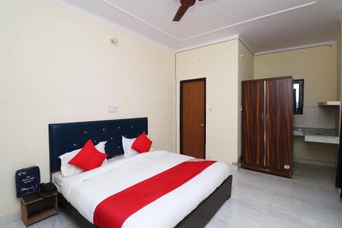 a bedroom with a large bed with red pillows at Hotel O JAGPAL STAY in Gurgaon
