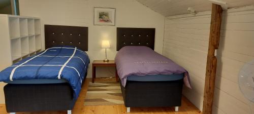 two beds sitting next to each other in a room at Tofta Konstgalleri-Lägenhet Loftet03 in Varberg
