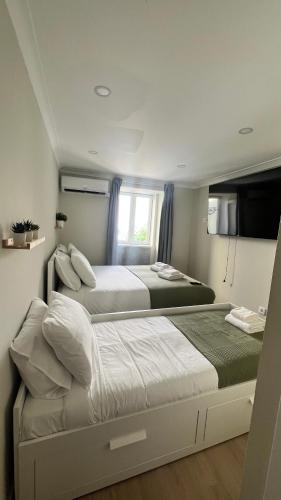 a bedroom with two beds and a window at Apartamento Central - Lisbon in Lisbon