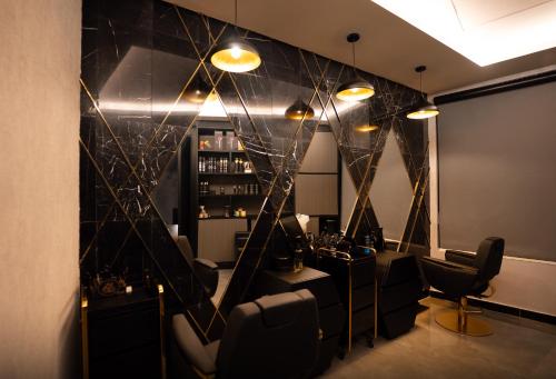 a room with a bar with black chairs and lights at The V Hotel in Baghdad