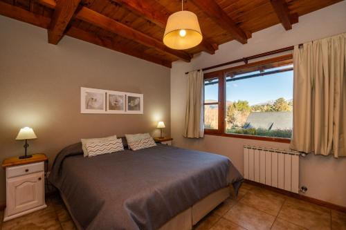 a bedroom with a bed and a large window at Posada de Montaña - Apart Hotel in San Carlos de Bariloche
