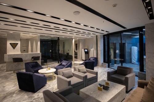 a living room with couches and chairs and a fireplace at The V Hotel in Baghdad