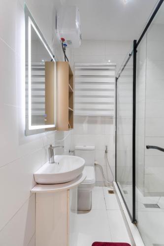 a white bathroom with a sink and a shower at Casa Aurelia Penthouse in Lekki